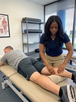Physical therapist performing manual therapy on a patient's lower leg at a sports physical therapy clinic in Orlando, FL